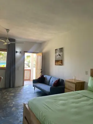 a living room with a bed and a couch at Habitacion 1 en Dani's Guest House in Las Galeras