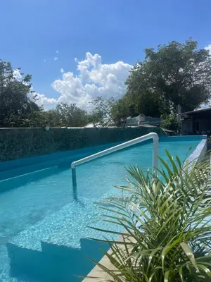 a swimming pool with a hand rail in the water at Habitacion 1 en Dani's Guest House in Las Galeras