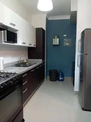a kitchen with a stove and a blue wall at Céntrico y acogedor apartamento en Bella Vista in Santo Domingo