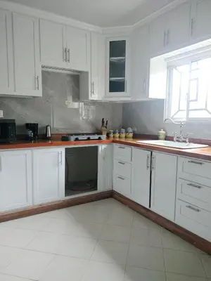 a white kitchen with white cabinets and a sink at Villa Magante in La Yagua