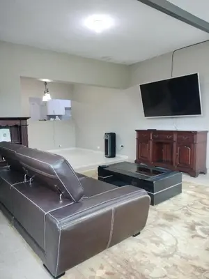 a living room with a leather couch and a flat screen tv at Villa Magante in La Yagua