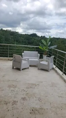 a patio with white furniture and a potted plant at Villa con piscina Infinitive in Concepción de La Vega