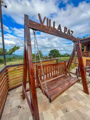 a swing on a porch with a view of a field at Villa Paz in San Felipe de Puerto Plata