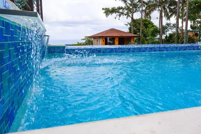a swimming pool with blue tiles on the side at Villa Paz in San Felipe de Puerto Plata