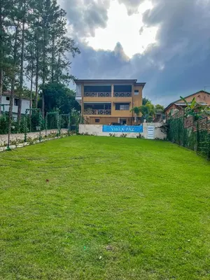 a building with a large yard in front of it at Villa Paz in San Felipe de Puerto Plata