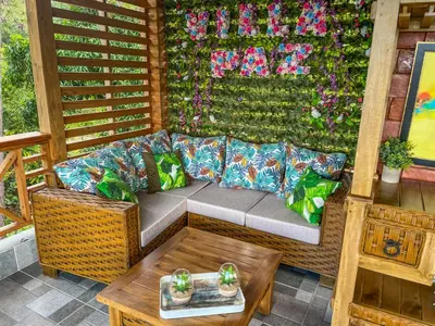 a couch on a porch with a wall with flowers at Villa Paz in San Felipe de Puerto Plata