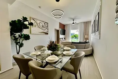 a dining room and living room with a table and chairs at Adult Only Luxe Retreat @ Coral Bay 2 in Punta Cana