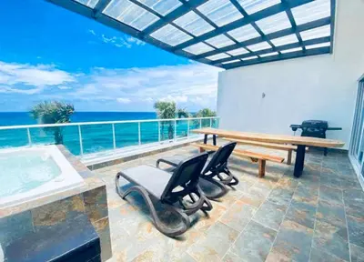 a room with a table and chairs and the ocean at Beachfront Luxury Penthouse in Sosúa