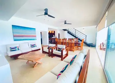 a living room with a couch and a table at Beachfront Luxury Penthouse in Sosúa