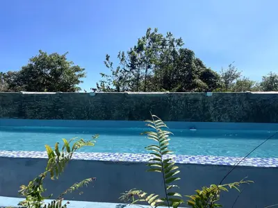 a retaining wall next to a blue swimming pool at Habitacion 3 en Dani's Guest House in Las Galeras