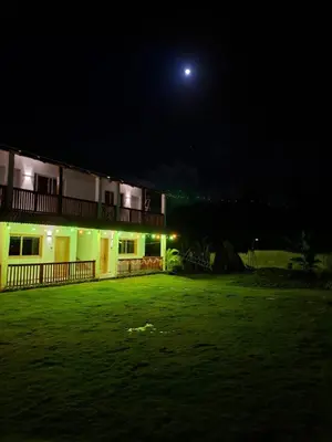 a house at night with the moon in the sky at Habitacion con Jacuzzy en Dani's Guest House in Las Galeras