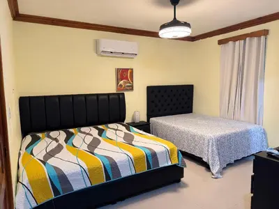 a bedroom with two beds and a window at Hotel El Bonao in Higuey