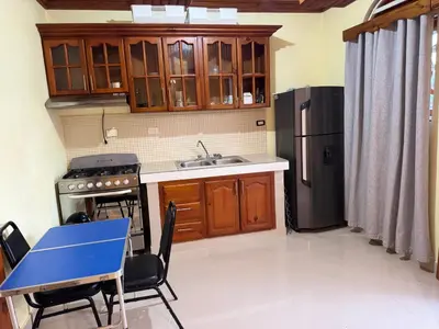 a kitchen with a blue table and a refrigerator at Hotel El Bonao in Higuey