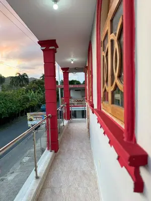 a balcony of a house with red columns at Hotel El Bonao in Higuey
