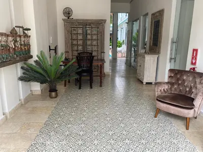 a hallway with a table and chairs and a table and a chair at Boutique Hotel Casa Grande, Parrot's Paradise Suite in Santo Domingo