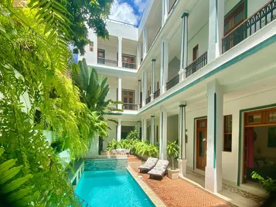 an exterior view of a building with a swimming pool at Boutique Hotel Casa Grande, Mandala Suite in Santo Domingo