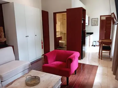a living room with a pink chair and a table at Boutique Hotel Casa Grande, Mandala Suite in Santo Domingo