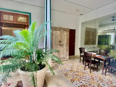 a dining room with a table and a palm plant at Boutique Hotel Casa Grande, Mandala Suite in Santo Domingo