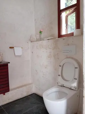 a white bathroom with a toilet and a window at Boutique Hotel Casa Grande, Banana Chica, Estudio superior con cocina in Santo Domingo