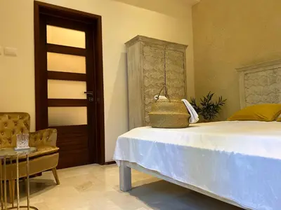 a bedroom with a bed and a chair and a door at Boutique Hotel Casa Grande, Banana Chica, Estudio superior con cocina in Santo Domingo