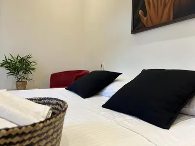 a bedroom with a bed with black pillows on it at Boutique Hotel Casa Grande, Chocolate Paradise, Estudio superior con Cocina in Santo Domingo