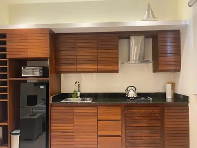 a kitchen with wooden cabinets and a sink at Boutique Hotel Casa Grande, Chocolate Paradise, Estudio superior con Cocina in Santo Domingo