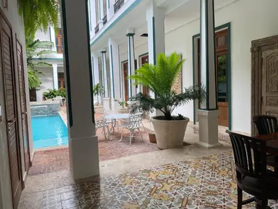 a hallway with a pool and a table and chairs at Boutique Hotel Casa Grande, Chocolate Paradise, Estudio superior con Cocina in Santo Domingo