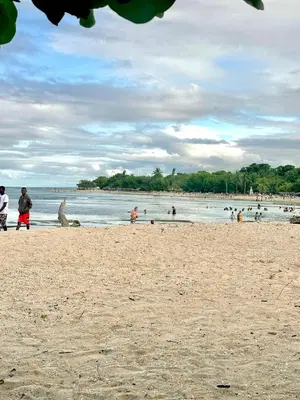 a group of people walking on a beach at Villas Jazmin in San Felipe de Puerto Plata