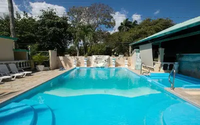 a large blue swimming pool in a yard at Villas Jazmin in San Felipe de Puerto Plata