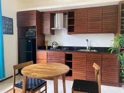 a kitchen with wooden cabinets and a wooden table and chairs at Boutique Hotel Casa Grande, Divas Suite in Santo Domingo