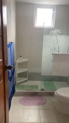 a bathroom with a shower with a toilet and a window at Edificio maremma 6 in Boca Chica
