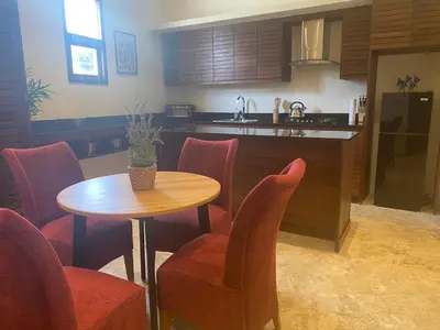a kitchen with a wooden table and chairs and a counter at Boutique Hotel Casa Grande, Dominican Voyage, Suite familiar de 2 dormitorios in Santo Domingo