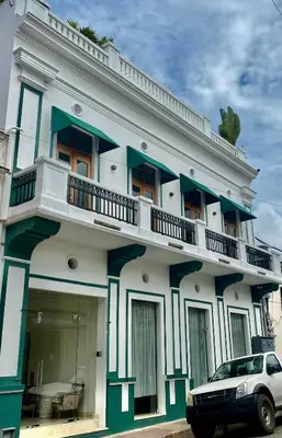 a building with a car parked in front of it at Boutique Hotel Casa Grande, Dominican Voyage, Suite familiar de 2 dormitorios in Santo Domingo
