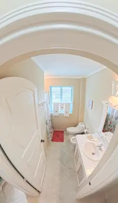 a white bathroom with two toilets and a sink at La Dolce Vita Beachfront Apt 9 in Las Terrenas