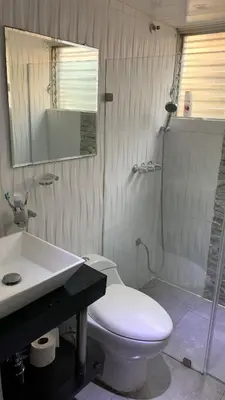 a bathroom with a white toilet and a sink at Comfortable apartment in Santo Domingo