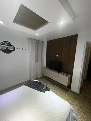a bedroom with a bed and a flat screen tv at Comfortable apartment in Santo Domingo