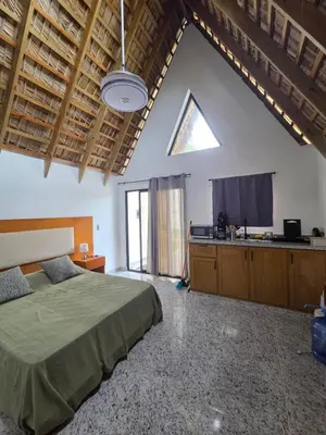 a large bedroom with a bed and a kitchen at Charming Bungalow with Pool in Sosúa