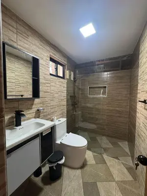 a bathroom with a toilet and a sink and a shower at Charming Bungalow with Pool in Sosúa