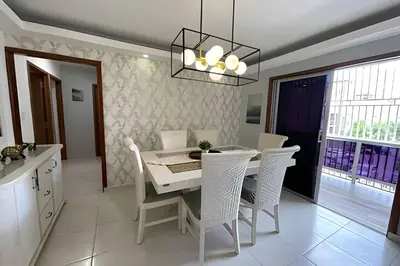 a dining room with a white table and chairs at Sunshine Palmares de Caleta in La Romana