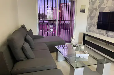 a living room with a couch and a glass table at Sunshine Palmares de Caleta in La Romana
