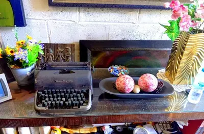 a desk with an old typewriter and eggs on a plate at Chalet Thevenin Art Accommodation in Jarabacoa