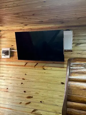 a flat screen tv hanging on a wooden wall at Villas Gabriel in Nagua