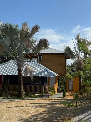 a house with palm trees in front of it at Villas Gabriel in Nagua