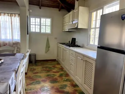 a kitchen with white cabinets and a refrigerator at Chalet Larimar Charming villa in Las Galeras in Las Galeras