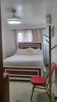 a bedroom with a large bed and a red chair at Luxury apartment Riviera Colonial in Calero