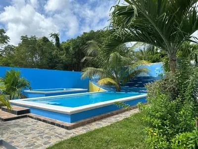 a swimming pool in a backyard with a blue fence at Apartamento Costero 1 en Las Galeras in Las Galeras