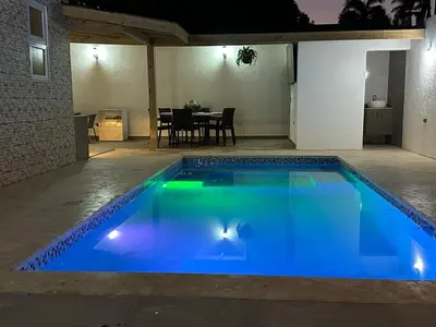 a blue swimming pool in a yard at night at mamajuana House in Las Terrenas