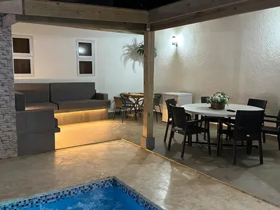 a living room with a table and a pool at mamajuana House in Las Terrenas