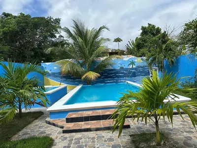 a swimming pool in a resort with palm trees at Apartamento Costero 2 en Las Galeras in Las Galeras