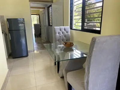 a dining room with a glass table and a refrigerator at Apartamento Costero 2 en Las Galeras in Las Galeras